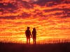 couple-silhouetted-against-dramatic-sunset_546192-31176